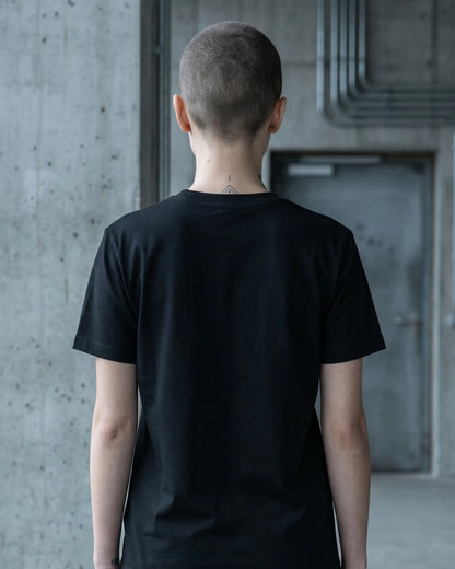 Weibliches Model mit schwarzem Stanley/Stella Crafter T-Shirt – Back, nachhaltig produziert aus Bio-Baumwolle, Label Natura Umbra.