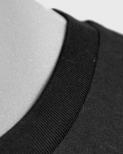 Detailaufnahme des Kragens am Stanley/Stella Crafter Unisex T-Shirt in Schwarz – hochwertiger Rippkragen aus GOTS-zertifizierter Bio-Baumwolle.