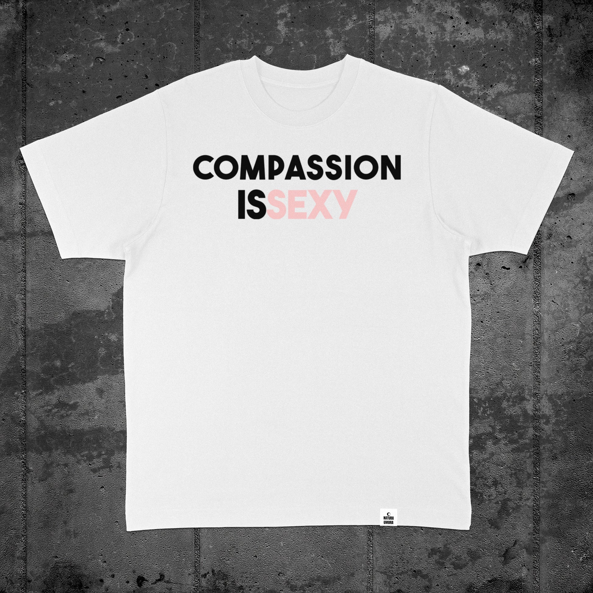 Nachhaltiges Oversized Unisex T-Shirt in Weiß mit Frontprint „Compassion is sexy“ – Flatlay des Stanley/Stella Freestyler von Natura Umbra.